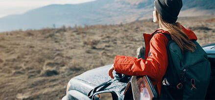 Girl stepping out of car overlooking a beautiful 